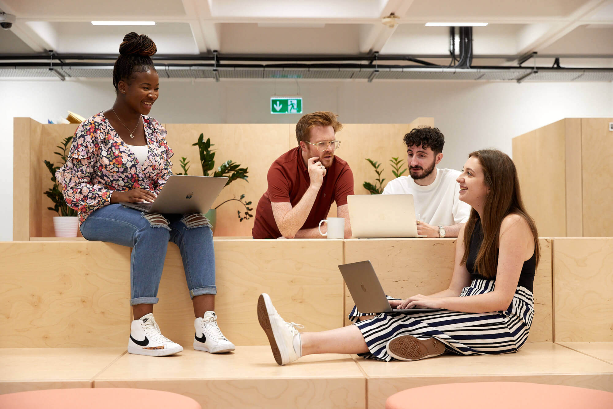 members of the little dot studios team sat on wooden blocks chatting